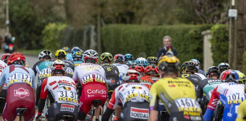 Beulle, France - March 10, 2019: Rear view of the peloton riding on Cote de Beulle during the stage 1 of Paris-Nice 2019. Beulle, France - March 10, 2019: Rear view of the peloton riding on Cote de Beulle during the stage 1 of Paris-Nice 2019